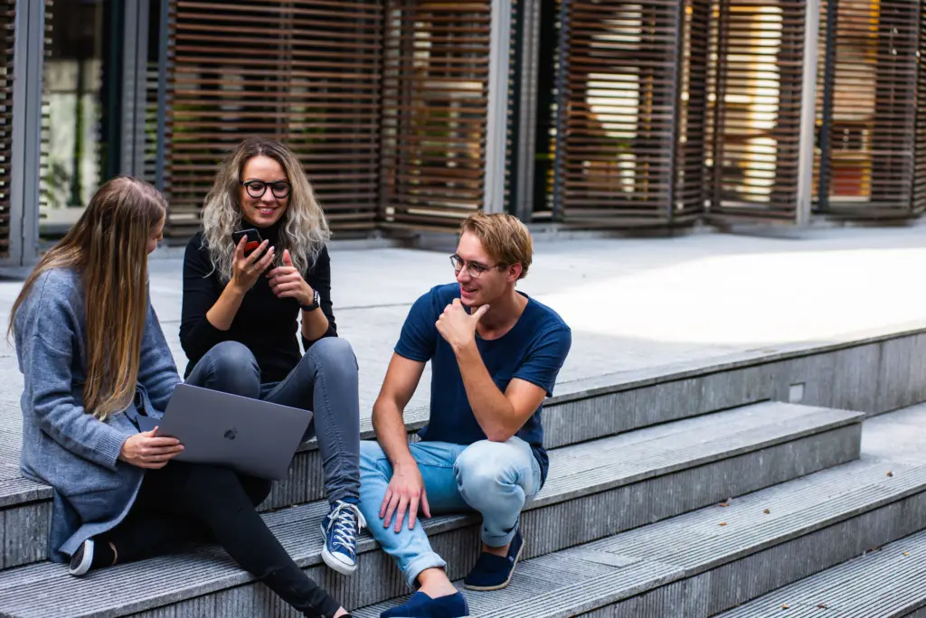3 college students sitting on stairs