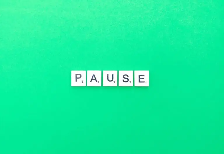 Scrabble letters spelling PAUSE on a bright green background.
