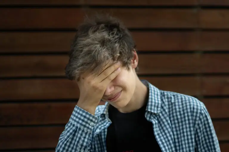 Young man covering his face with his hand