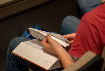 Young man turning pages in his bible.